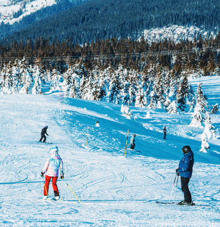 Panoramic view over a ski resort with people in chair lifts and majestic mountains in the background. High quality photoのeditorial素材