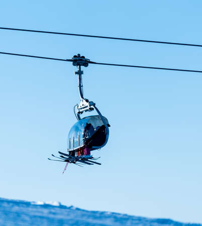 Family riding a ski lift to the top of a mountain at a ski resort.