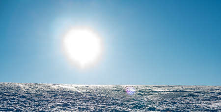 Close up of a ski resort slope with packed snow and bright sunshine.の写真素材