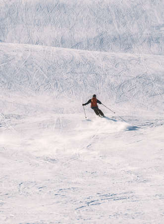 Alpine skier on a steep downhill slope at a winter sports resort. High quality photoの写真素材