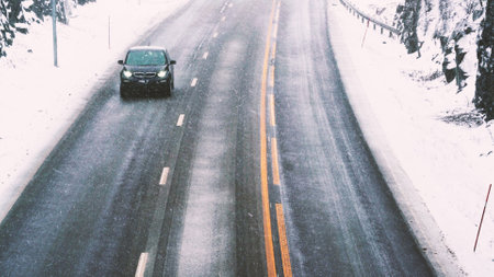 Car driving on a highway with wet slippery asphalt during a snow storm. Shallow depth of field, Motion blur. . High quality photoの写真素材