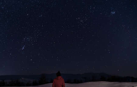 Person looking up at a clear and starry night sky on a cold clear winters night. High quality photoの写真素材