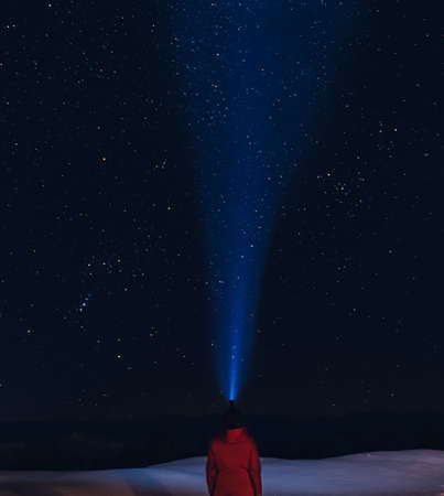 Person lighting up the starry night sky with a head torch while stargazing in the mountains. . High quality photoの写真素材