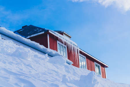 Long and massive icicles hanging from the roof of an old building. . High quality photoの写真素材