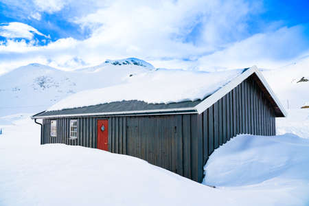 Cabin in the mountains covered in deep snow on a clear cold winters day. High quality photoの写真素材