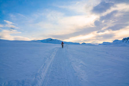 Person in the distance on a trail in deep snow on the mountain highlands.の写真素材