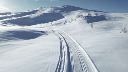 Cross country skiing slope running though stunning snow covered mountain.の写真素材