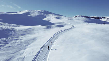 Active couple cross country skiing on a slope.