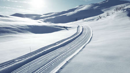 Cross country skiing slope running though stunning snow covered mountain.