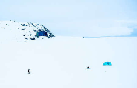 People Snowkiting on a frozen snowy mountain plain on a cold winters day.のeditorial素材