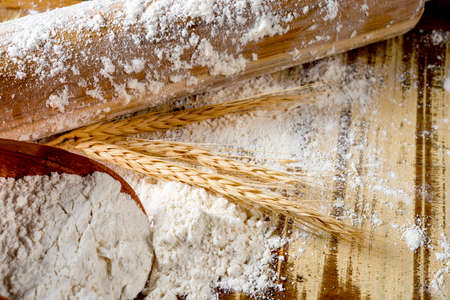 rolling pin, wheat and flour on the wooden table .の写真素材