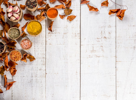 white wood background with leaves of copper color and spices pot, free space for text, top view, copy space.の写真素材