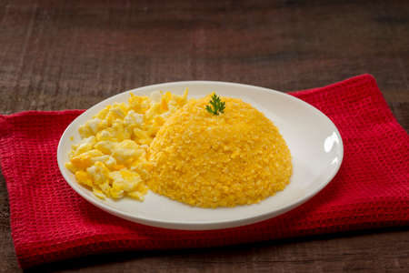 couscous with scrambled eggs on red fabric on wood