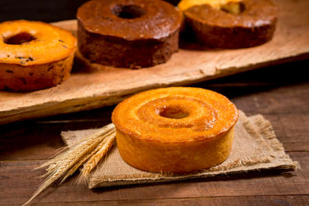 wheat flour cake on wood with other cake flavors in the background with wheat branch beside.の写真素材