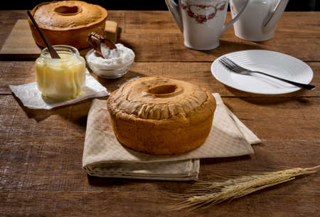 whole cake of condensed milk on fabric and rustic wood with pot of baking powder and cake in the...