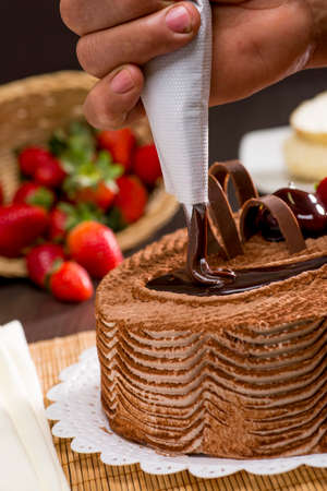 confectioner applying chocolate on pie