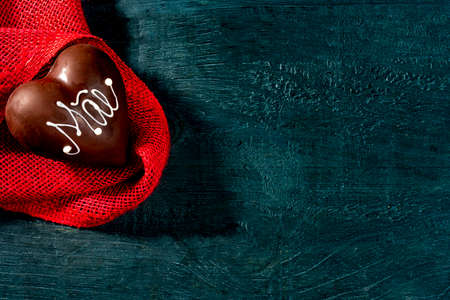chocolate hearts with writing in Portuguese  ââ mÃ£e ââ, on red fabric, top view, space for textの写真素材