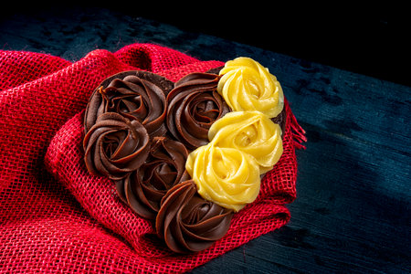 heart shape made with dark and white chocolate over red rustic backの写真素材