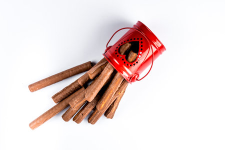 Chocolate covered wafer roll in red pot on white background, top viewの写真素材