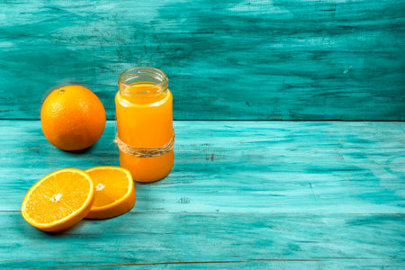 Fresh orange juice in a glass jar. On a blue background.の写真素材