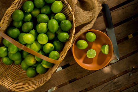 lime picked and sliced ââon wood and inside a basket  top view.の写真素材