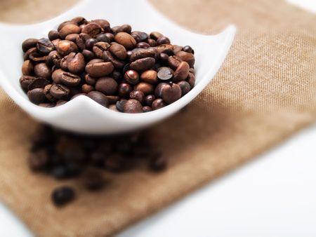 Coffee beans in a white plateの写真素材
