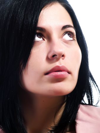 A closeup portrait about an elegant trendy woman with black hair who is looking up and she is dreaming something. She is wearing a pink stylish coat.の写真素材