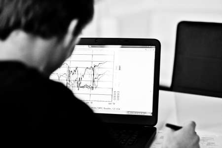 working men in front of a Laptop with financial graphic