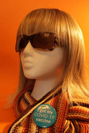 Women or girl face, wig blonde haired, the COVID-19 badge pinned and the words I got Covid -19...