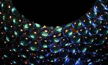 Abstract design,small blue glass lenses,decorative nuggets on a dark background.