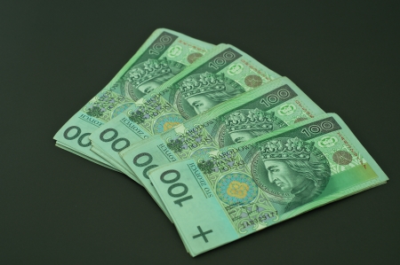 Polish banknotes distributed on a black background