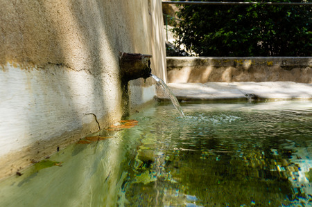Ancient fountain with crystal clear water straight from the mountains, cool!の写真素材