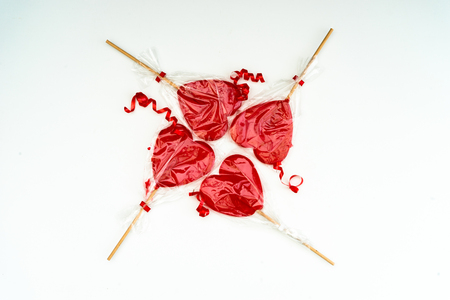 Colourful lollipop in the shape of a heart isolated on white background, a festive treat, a gift favorite, original declaration of loveの写真素材