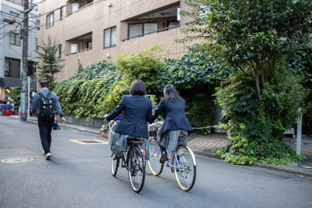 Tokyo, Japan, October 28, 2023: Cyclists Riding Along a Green Urban Pathwayのeditorial素材