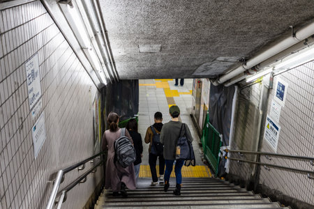 Tokyo, Japan, October 29, 2023: Commuters descending stairs in subway station passageのeditorial素材