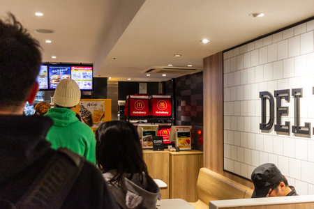Tokyo, Japan, October 29, 2023: Customers lining up at a fast food restaurant counterのeditorial素材