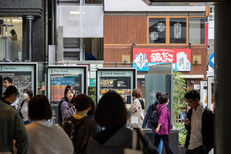 Tokyo, Japan, October 29, 2023: People walking past a variety of shops in a busy urban areaのeditorial素材