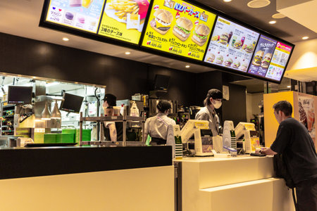 Tokyo, Japan, October 29, 2023: Customer ordering at a fast food restaurant with digital menu displaysのeditorial素材