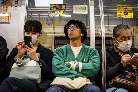 Tokyo, Japan, October 29, 2023: Commuters using smartphones on the subwayのeditorial素材