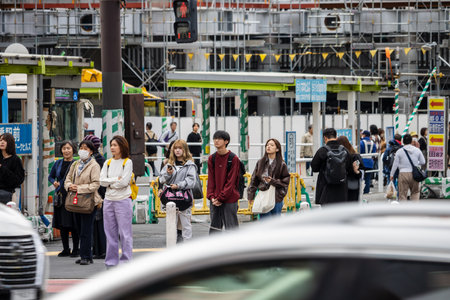 Tokyo, Japan, October 29, 2023: Pedestrians crossing a busy intersection in front of a construction siteのeditorial素材