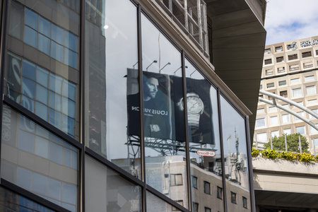 Tokyo, Japan, October 29, 2023: Reflection of Louis Vuitton Advertisement on Glass Buildingのeditorial素材