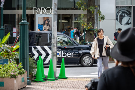 Tokyo, Japan, October 29, 2023: Uber Vehicle and Pedestrians in Tokyo Streetのeditorial素材
