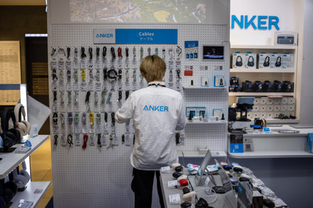 Tokyo, Japan, October 29, 2023: Employee organizing ANKER technology products in a storeのeditorial素材