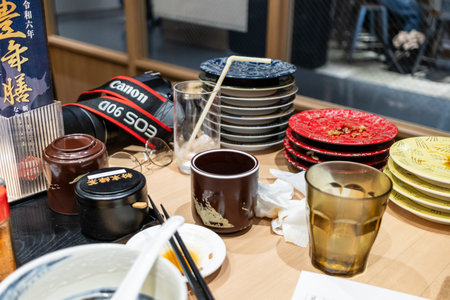 Tokyo, Japan, October 29, 2023: Aftermath of a sushi meal with stacked plates on a restaurant tableのeditorial素材