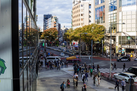Tokyo, Japan, October 29, 2023: Reflection of a busy Tokyo intersection in modern glass building facadeのeditorial素材