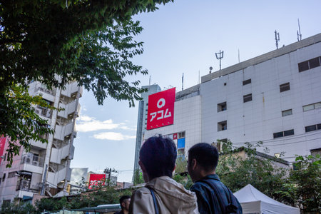 Tokyo, Japan, October 29, 2023: Couple looking at urban skyline with bold advertising signsのeditorial素材