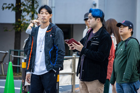 Tokyo, Japan, October 29, 2023: Young individuals with unique hairstyles waiting at a pedestrian crossingのeditorial素材