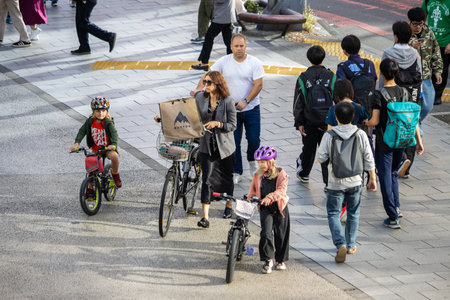 Tokyo, Japan, October 29, 2023: Family on bicycles at city crossingのeditorial素材