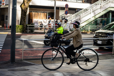 Tokyo, Japan, October 29, 2023: Cyclist in business attracts riding through Tokyo's busy streetsのeditorial素材