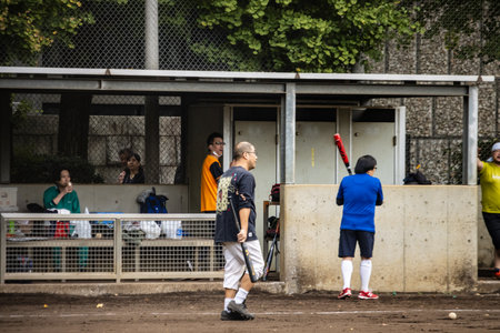 Tokyo, Japan, October 31, 2023: Young Athletes Playing Baseball in Urban Parkのeditorial素材